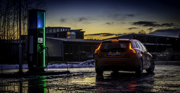 Laddstation för elbil med en röd elbil stående bredvid