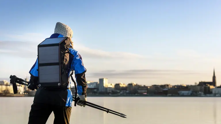 Kvinna åker skridskor på isen med Luleå stad i bakgrunden